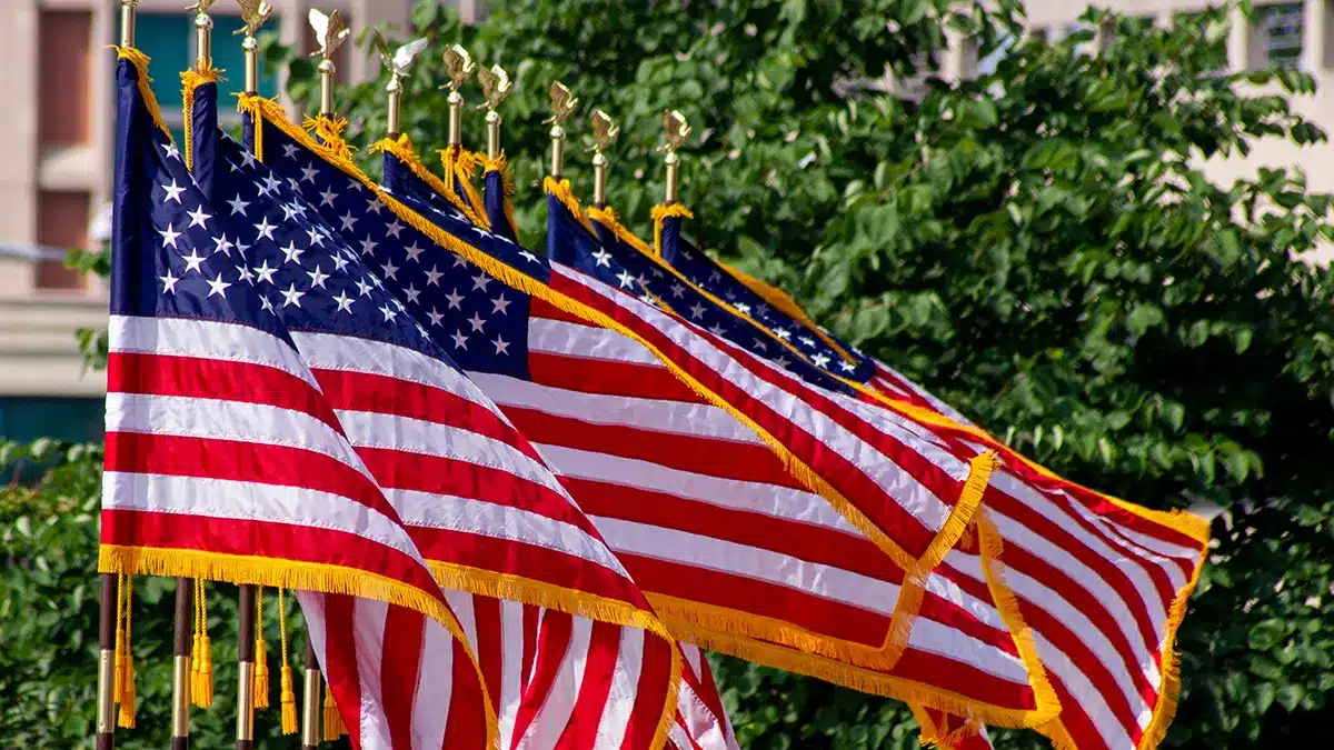 Several American flags flying together in good condition on outdoor poles