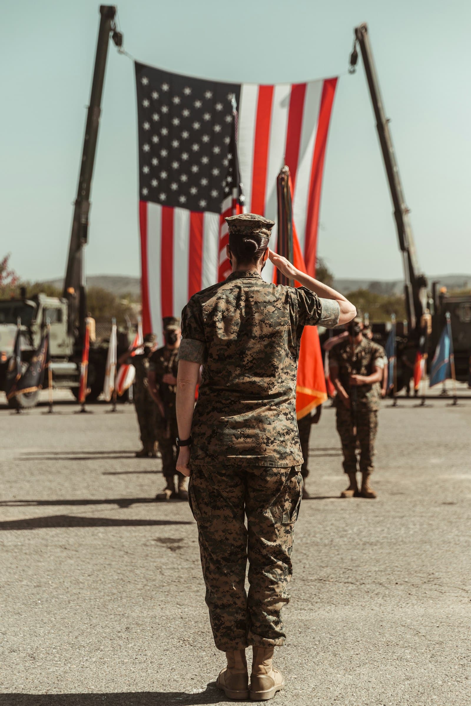Marines in uniform holding American flags during a ceremony at Camp Pendleton