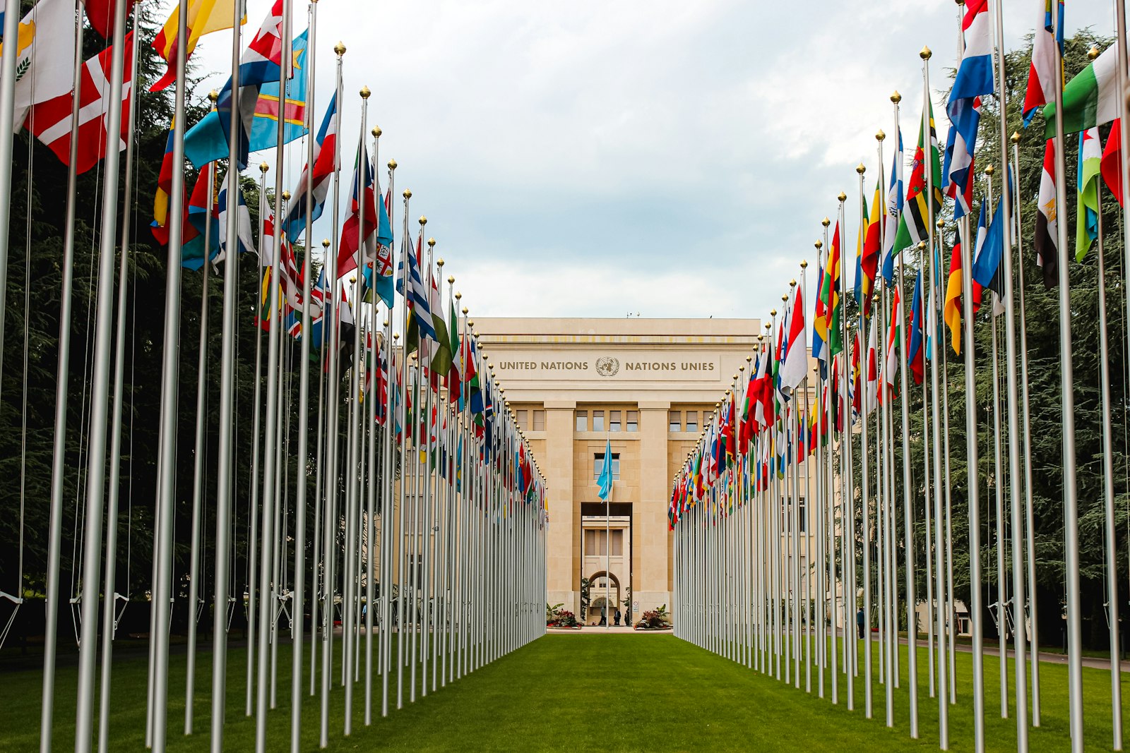 Two long rows of UN member state flags on identical poles of the same height at the United Nations office in Geneva
